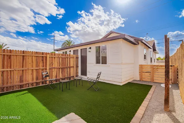 a backyard of a house with table and chairs