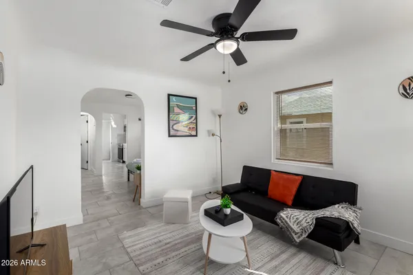a living room with furniture and a ceiling fan