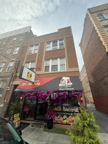 a front view of small building with cars parked