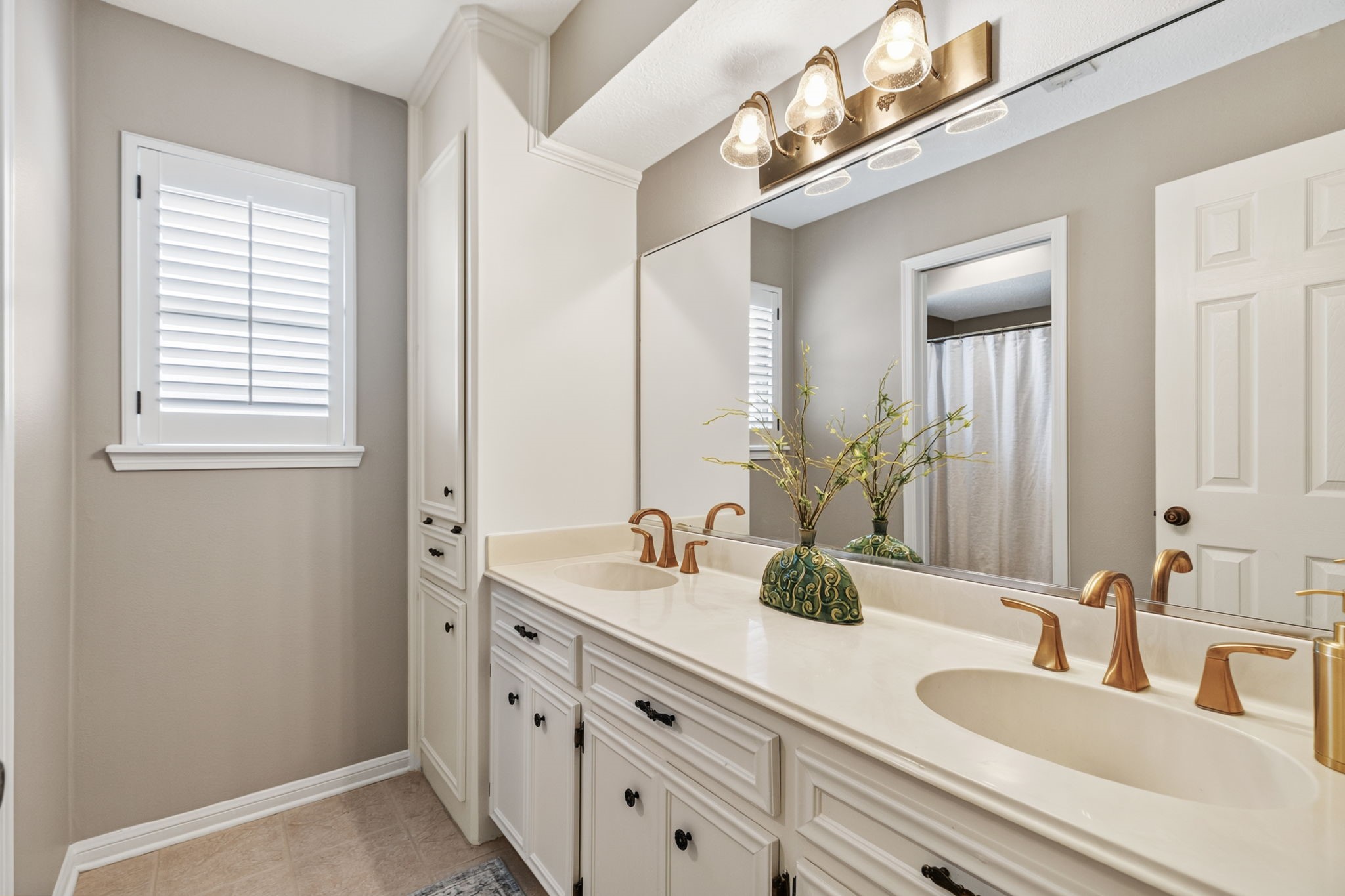 3414 Flaming Candle Drive Spring, TX 77388 - Photo 38 of 50 UPSTAIRS HALL BATHROOM - This bathroom has plenty of storage space & double sinks. Faucets and lighting have recently been replaced. There is a pocket door separating the sink area from the tub & toilet area. You can see that space in the mirror reflection. The windows in both of these rooms also have plantation shutters.