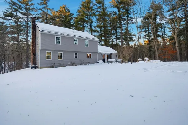 a front view of a house with a yard covered in snow