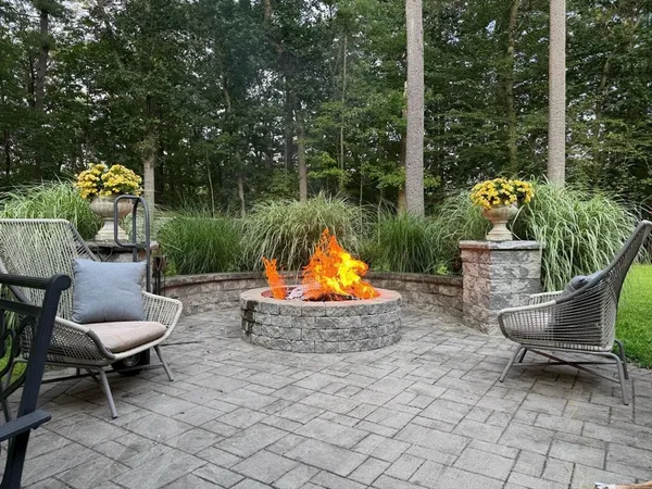 a backyard of a house with fountain table and chairs