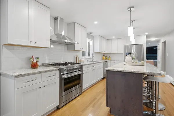 a kitchen with stainless steel appliances granite countertop a sink stove and refrigerator