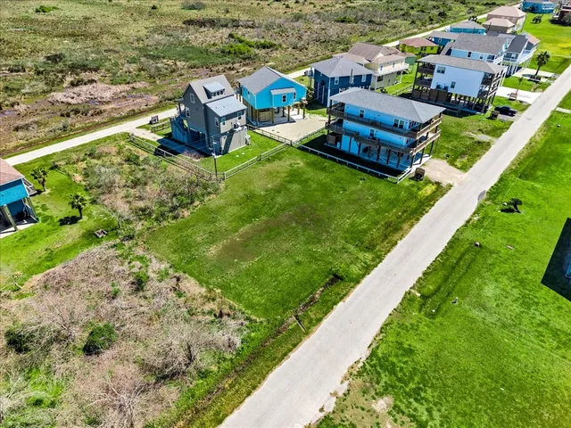 an aerial view of a house with a garden and lake view