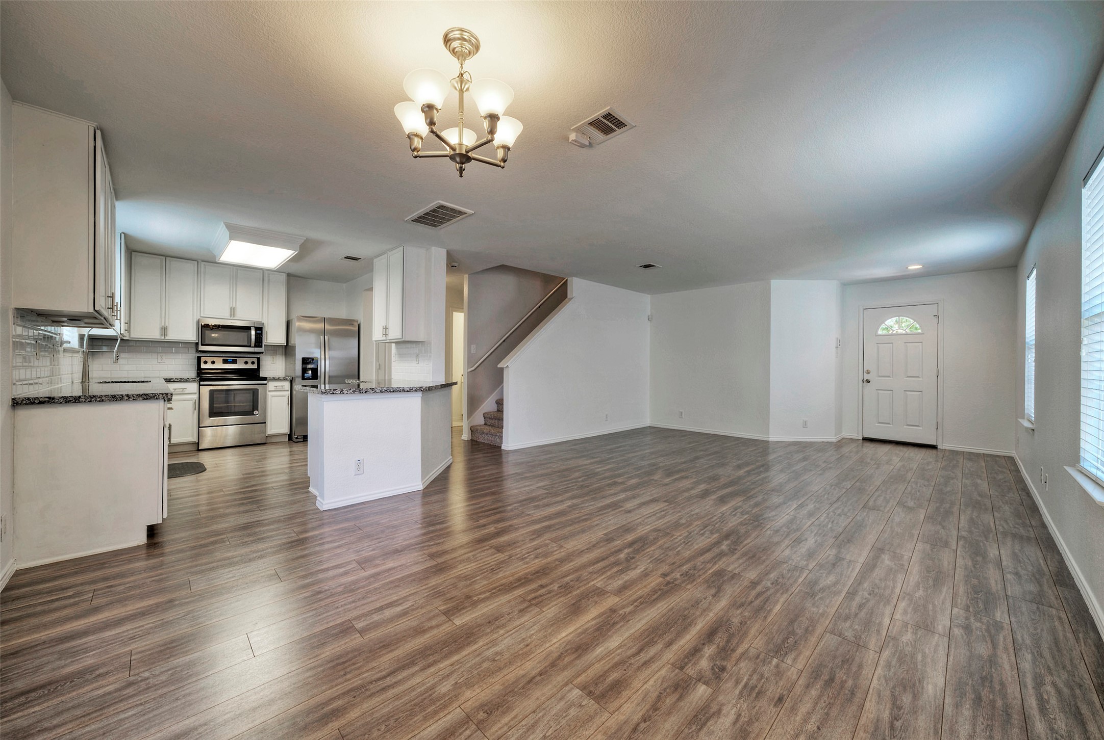 140 Plum Path Kyle, TX 78640 - Photo 4 of 22 a view of a kitchen with a sink and dishwasher a refrigerator with wooden floor