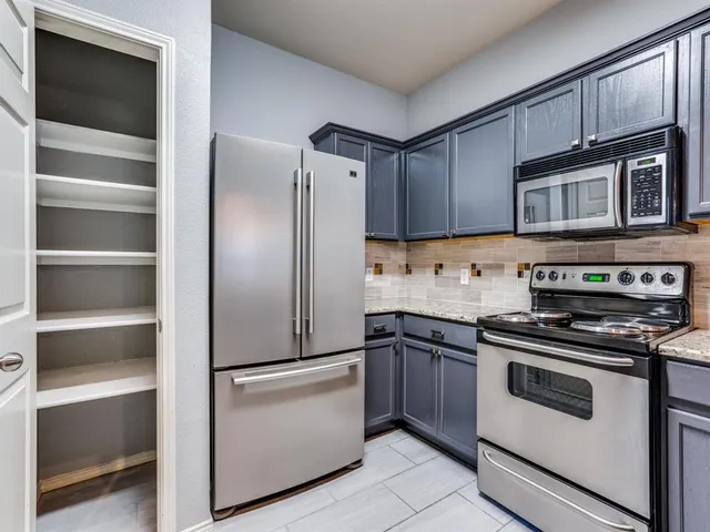a kitchen with stainless steel appliances and cabinets