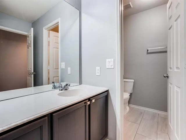 a bathroom with a sink a toilet and mirror