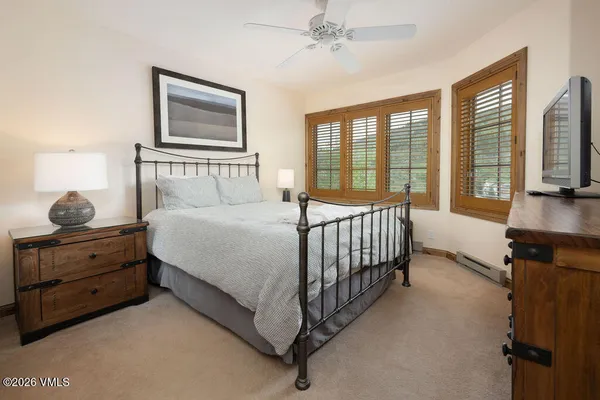 a bedroom with a bed and a flat tv screen on the dresser