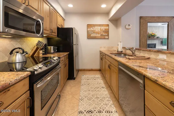 a kitchen with stainless steel appliances granite countertop a stove and a sink