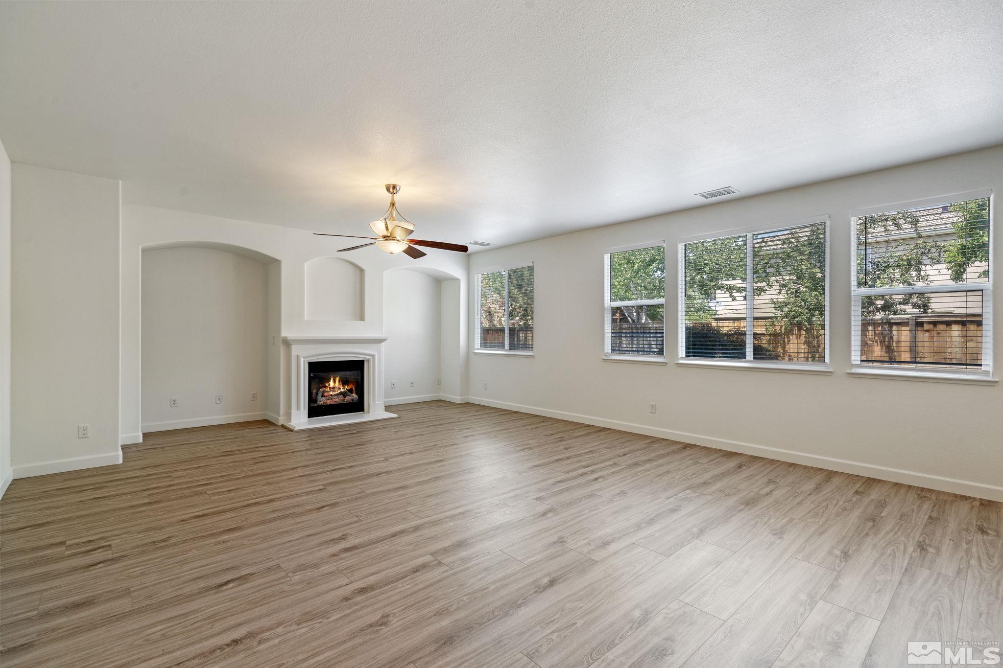 485 Teramo Court Reno, NV 89521 - Photo 8 of 37 wooden floor fireplace and windows in an empty room