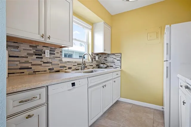 a kitchen with granite countertop white cabinets and white appliances