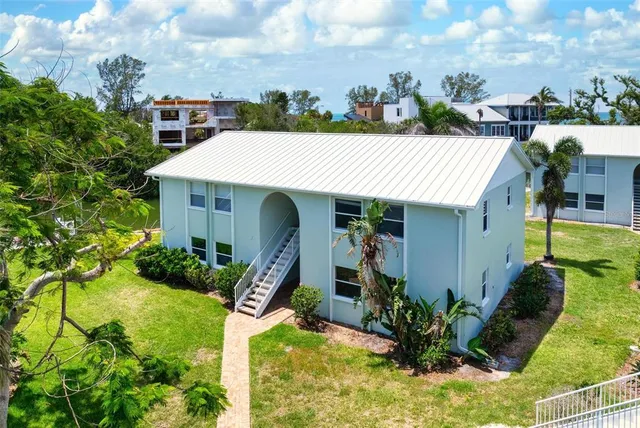 an aerial view of a house with a garden and lake view