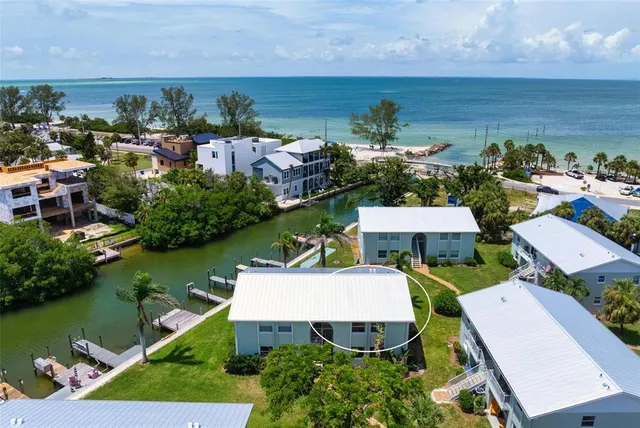 an aerial view of a house with a garden and lake view
