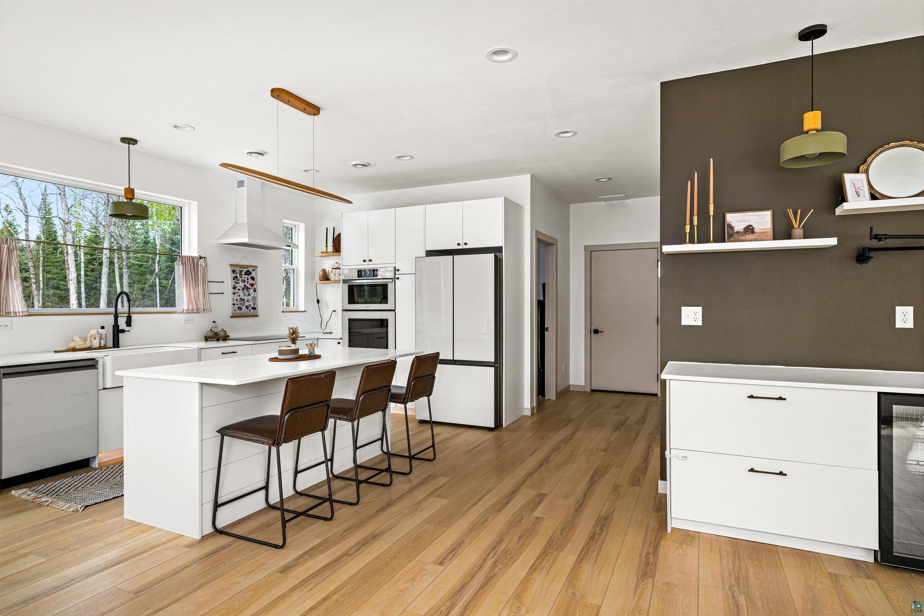 1825 East Shilhon Road Duluth, MN 55804 - Photo 13 of 37 Open-concept kitchen featuring vinyl style plank flooring and a central island with countertop seating.