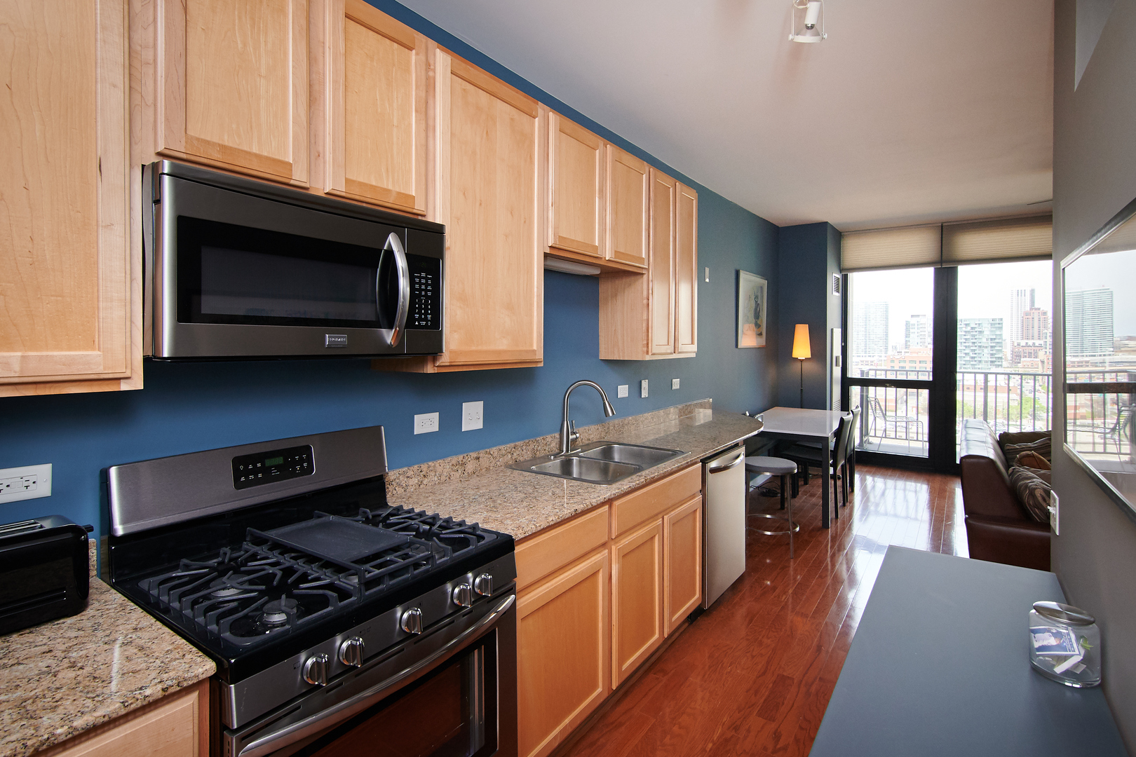 210 South Desplaines Street, Unit 1003 Chicago, IL 60661 - Photo 11 of 27 a kitchen with stainless steel appliances granite countertop wooden cabinets stove top oven and sink