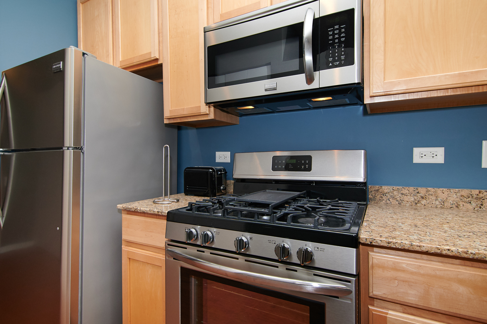210 South Desplaines Street, Unit 1003 Chicago, IL 60661 - Photo 12 of 27 a kitchen with stainless steel appliances granite countertop a stove and a microwave