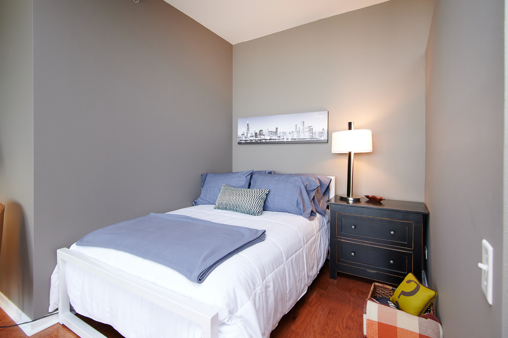 210 South Desplaines Street, Unit 1003 Chicago, IL 60661 - Photo 13 of 27 a bedroom with a bed and a lamp on dresser