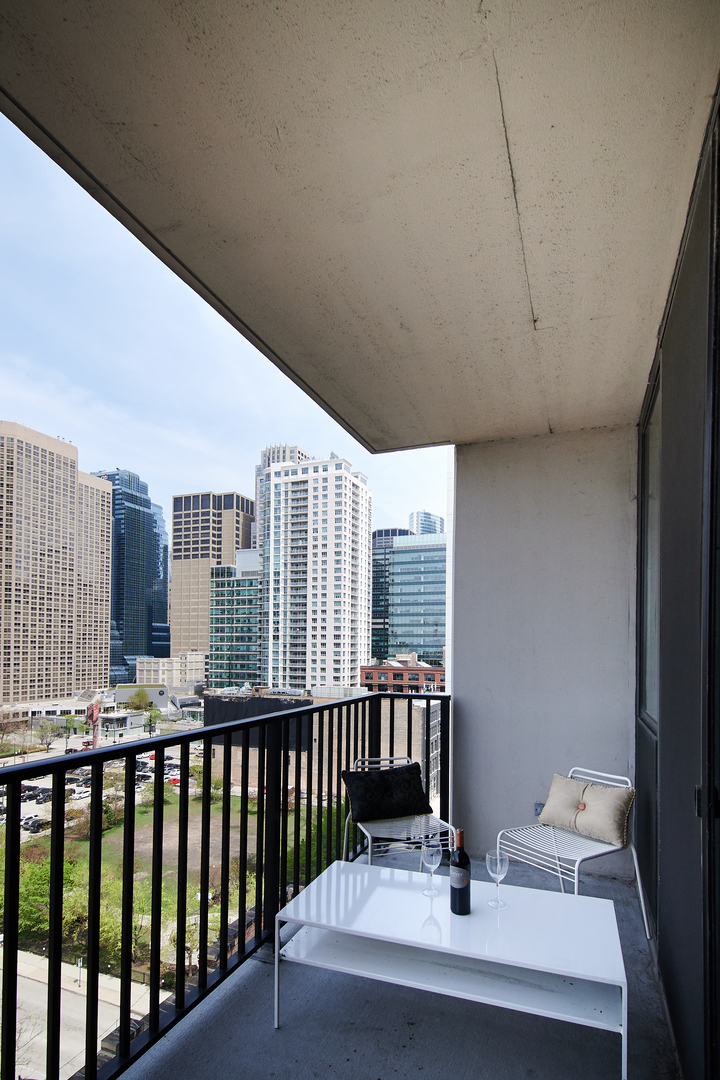 210 South Desplaines Street, Unit 1003 Chicago, IL 60661 - Photo 19 of 27 a balcony with a table and chairs