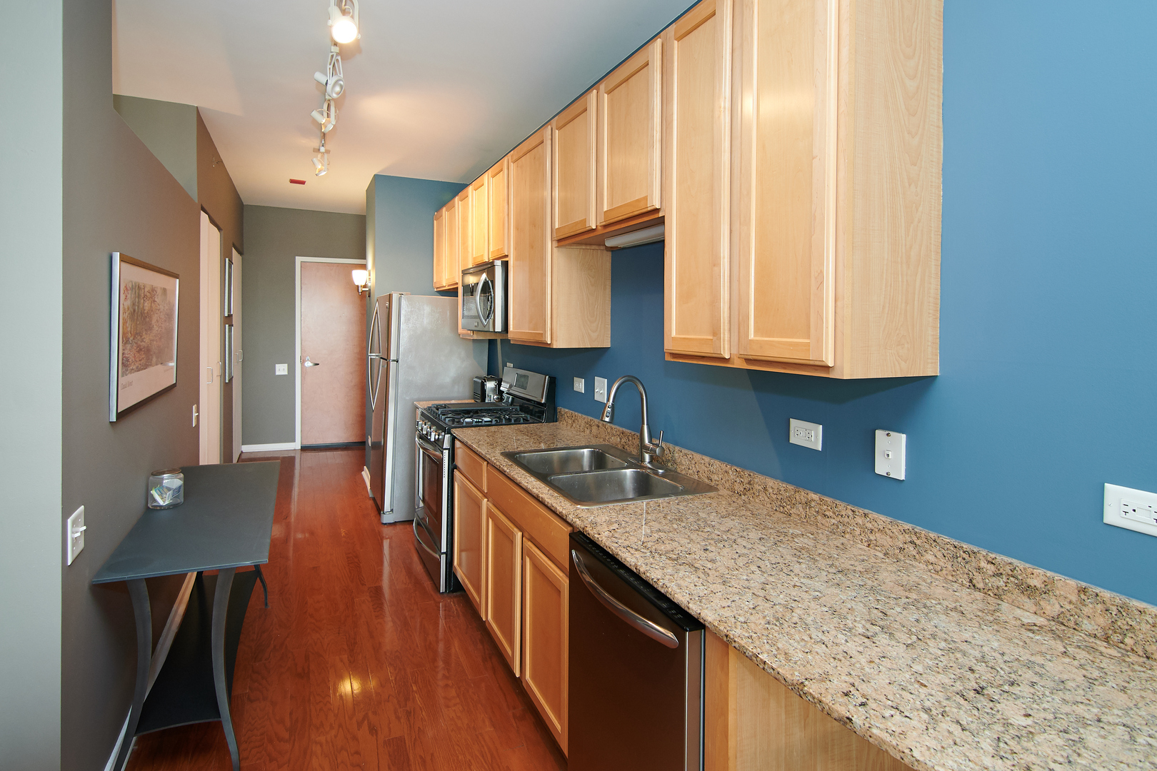 210 South Desplaines Street, Unit 1003 Chicago, IL 60661 - Photo 10 of 27 a kitchen with stainless steel appliances granite countertop a sink a refrigerator and a stove