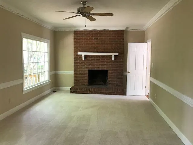 an empty room with windows and fireplace