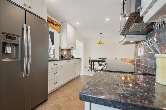 a kitchen with stainless steel appliances kitchen island granite countertop a refrigerator and a stove
