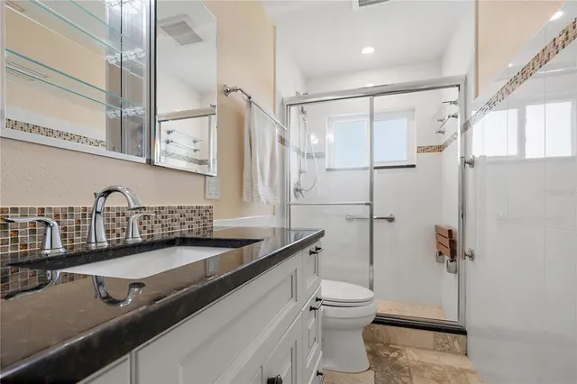 a bathroom with a sink toilet and shower