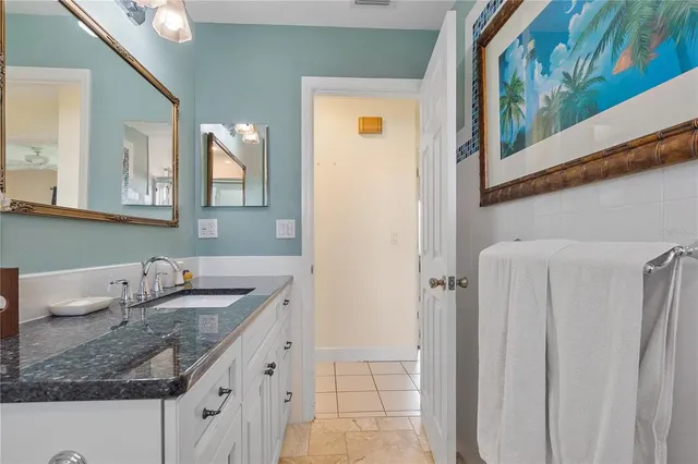 a bathroom with a granite countertop sink and a mirror
