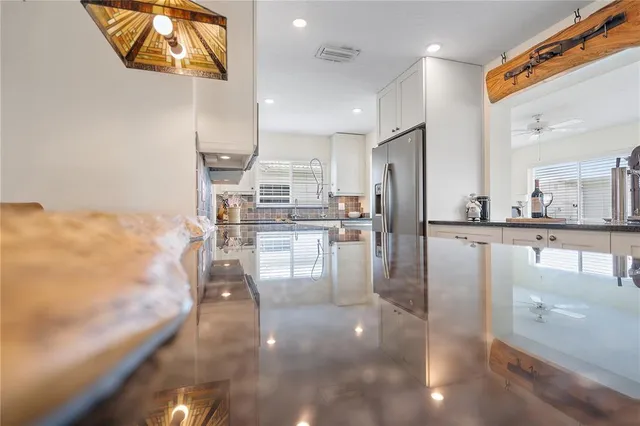 a kitchen with stainless steel appliances kitchen island granite countertop a refrigerator a stove and a sink with granite countertops