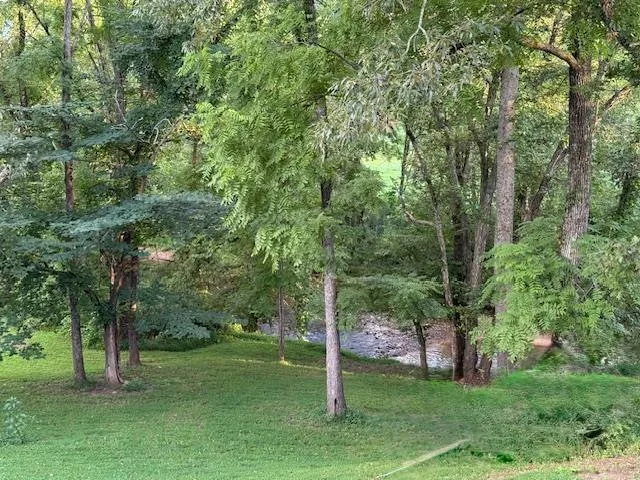 a view of a hallway with wooden floor and a living room