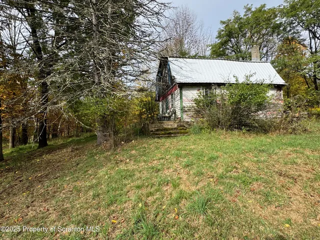 a view of a wooden house with a yard