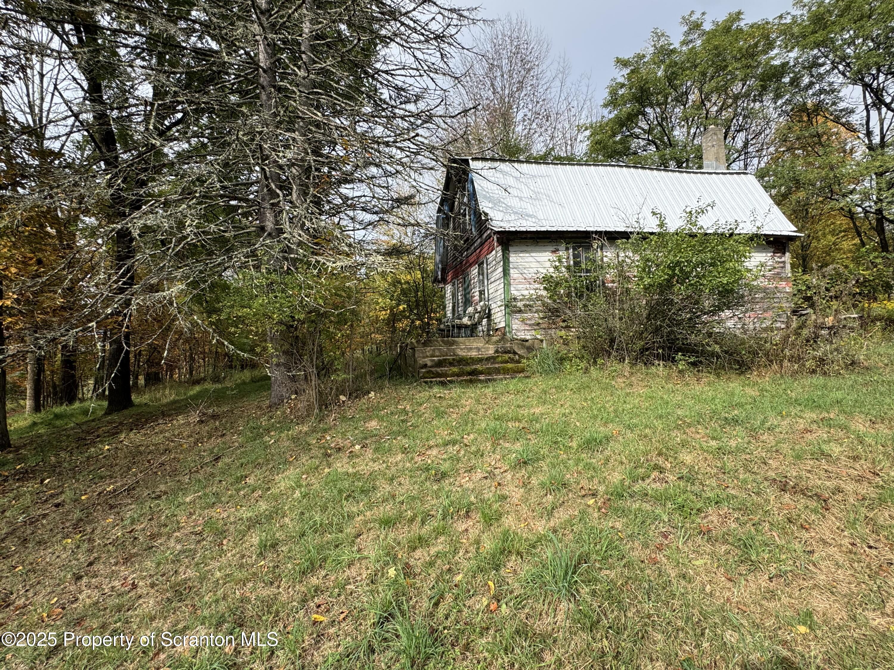 636 Darrow Road New Milford, PA 18834 - Photo 8 of 25 a view of a wooden house with a yard