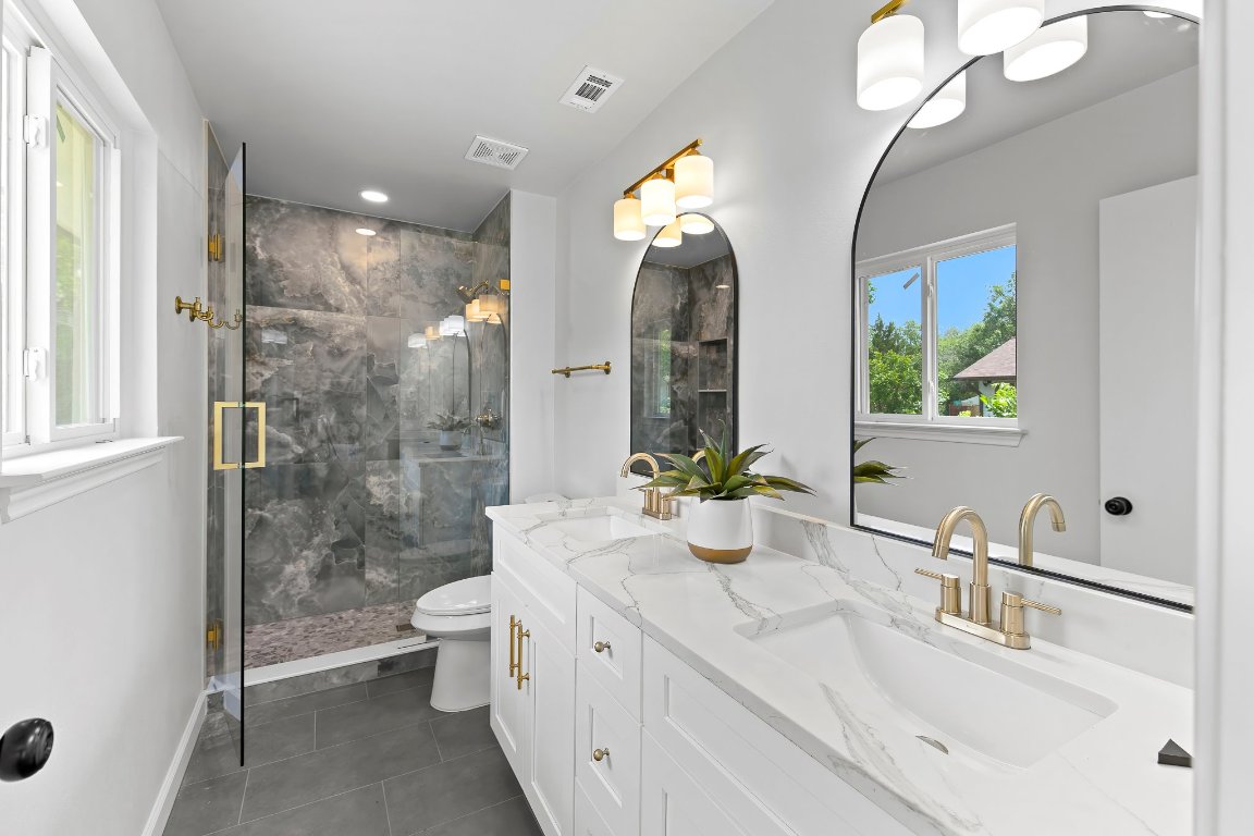 7302 Hartnell Drive Austin, TX 78723 - Photo 12 of 23 a bathroom with a double vanity sink toilet and shower
