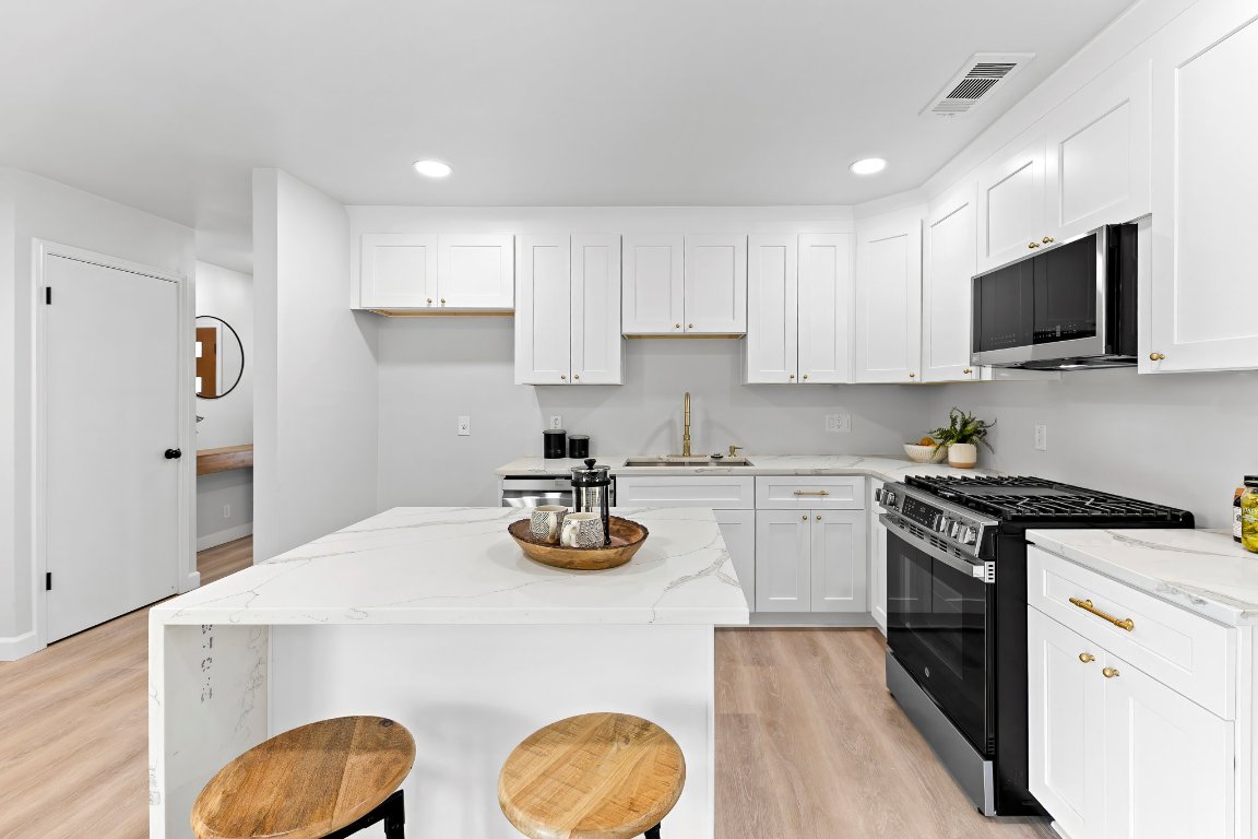 7302 Hartnell Drive Austin, TX 78723 - Photo 5 of 23 a kitchen with a sink a stove and cabinets