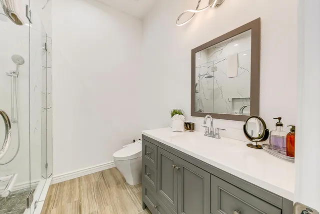 a bathroom with a sink and a mirror with toilet