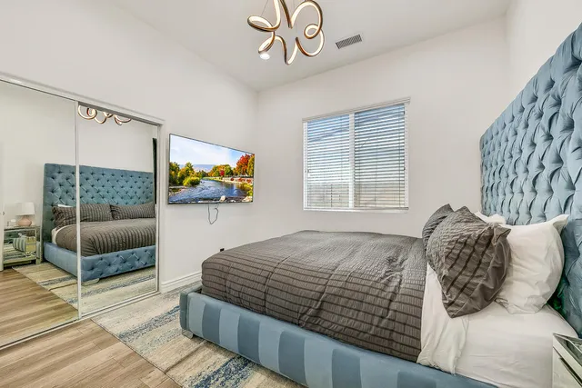 a bedroom with a bed and a flat screen tv