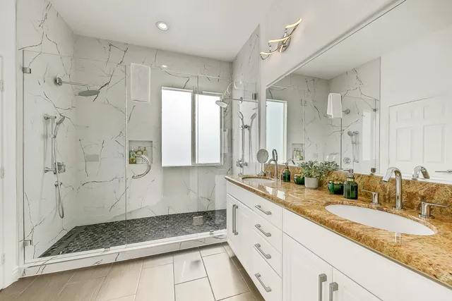 a bathroom with a granite countertop sink mirror and a shower