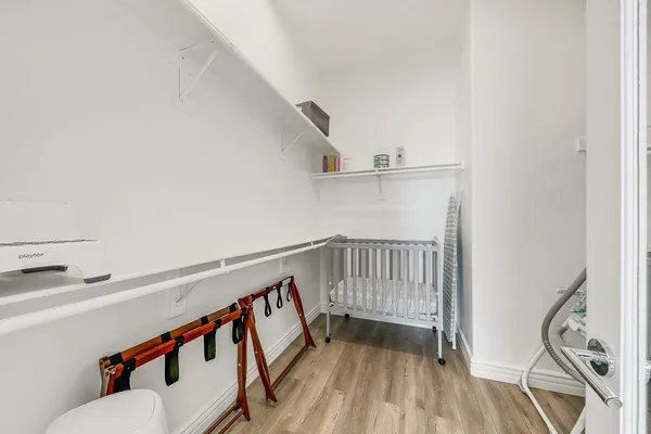 a hallway with wooden floor and white walls