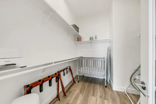 a hallway with wooden floor and white walls