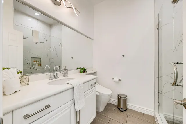 a bathroom with a granite countertop sink mirror and toilet