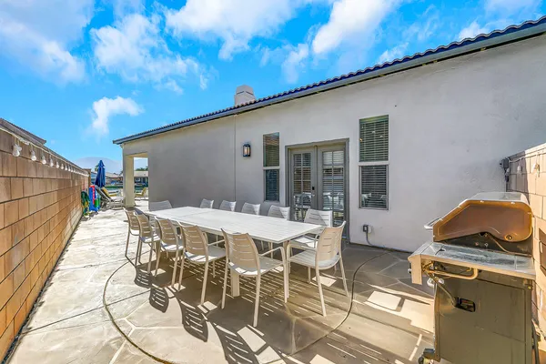 a patio with table and chairs and potted plants