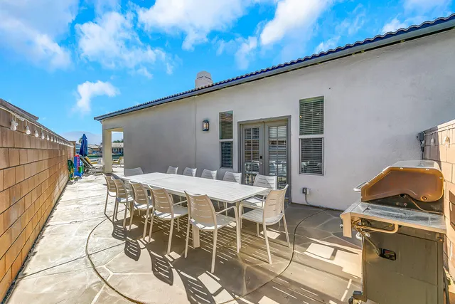 a patio with table and chairs and potted plants