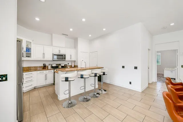 a kitchen with white cabinets and appliances
