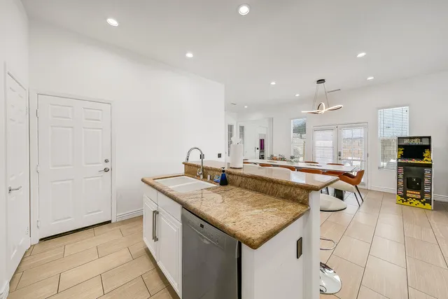 a kitchen with stainless steel appliances granite countertop a sink and a refrigerator