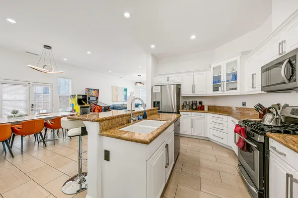 a kitchen with a sink a stove and chairs