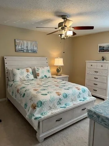 a bedroom with a bed and ceiling fan