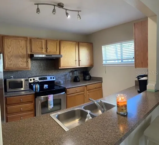 a kitchen with stainless steel appliances granite countertop a sink stove and window