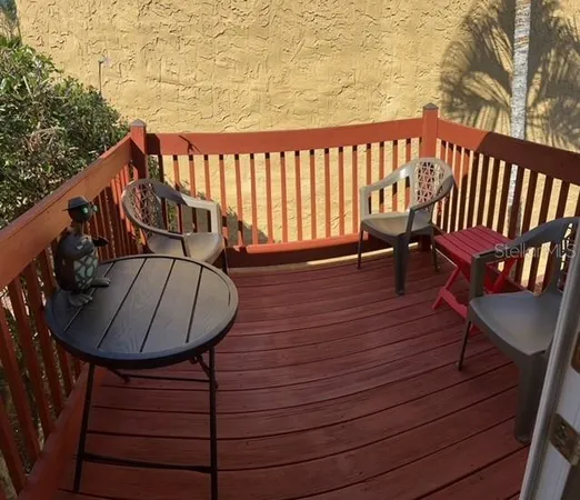 a balcony with wooden floor outdoor seating and stairs