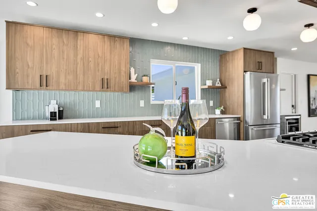 a large kitchen with a large counter top stainless steel appliances and cabinets