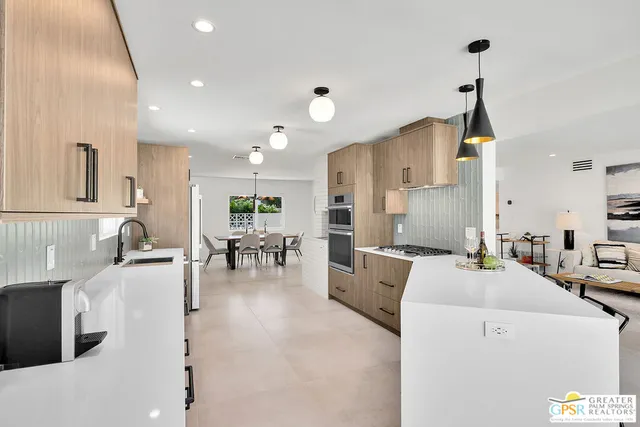 a living room with furniture a wooden floor and a chandelier