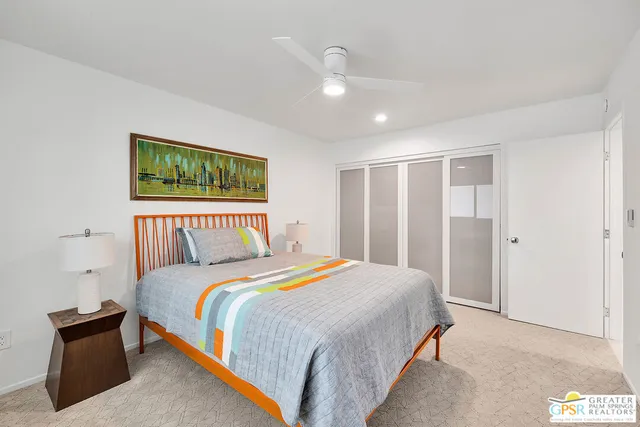 a bedroom with a bed and a painting on the wall